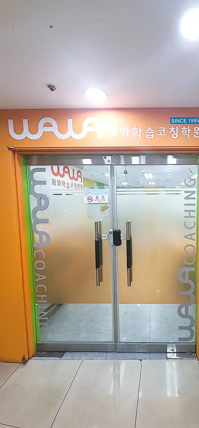 주황색 벽에 WAWA 로고가 붙은 상남점 유리문 출입구