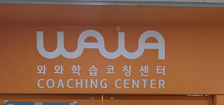 주황 벽면에 흰색 와와학습코칭센터 로고가 걸린 부평점 출입구 간판